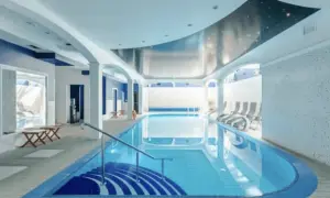 Basen w hotelu z niebieskimi akcentami i sufitem imitującym nocne niebo. Idealne miejsce dla najlepszych hoteli nad morzem w Polsce.