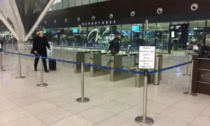 Odprawa na prom w terminalu lotniska. Ludzie przechodzą przez bramki, przygotowując karty pokładowe.