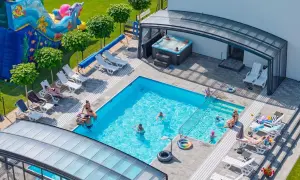 Relaks w apartamentach nad morzem z basenem. Dzieci bawią się na dmuchanym zamku, dorośli odpoczywają przy basenie i w jacuzzi.