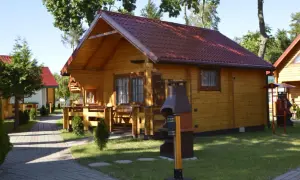 Drewniane domki letniskowe z czerwonymi dachami, idealne na wypoczynek. Sianożęty domki przy plaży czekają na gości.