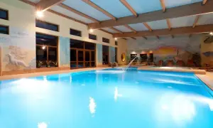 Basen w Jantar Niechorze SPA z wodnym placem zabaw i malowidłami na ścianach.