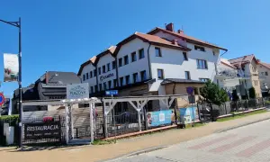 Ośrodek Kamena Karwia to biały budynek z czerwonym dachem, obok restauracja Plażova.