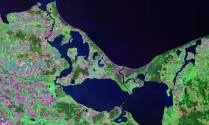 Widok satelitarny wybrzeża z zatokami i polami uprawnymi. Trudno ocenić, ile jest wysp w Polsce, ale ten obszar pokazuje ich fragment.