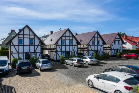 Uroczy ośrodek wypoczynkowy razem nad morzem. Domy w stylu szachulcowym, parking pełen samochodów, gotowych na wakacyjne przygody.