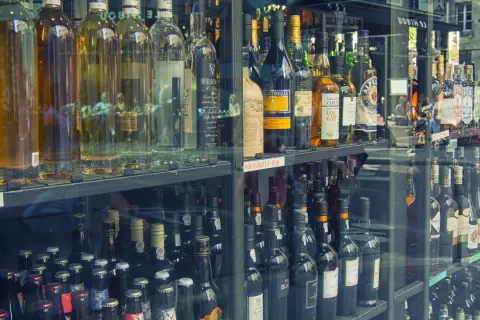 Butelki z alkoholem w witrynie sklepowej. Zastanawiasz się, ile alkoholu można przewieźć samolotem do Norwegii?