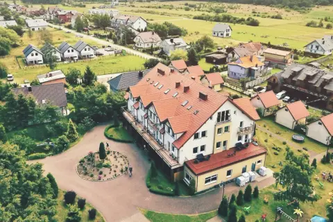 Widok z lotu ptaka na kompleks wypoczynkowy Sedna z hotelami, domkami i placem zabaw.