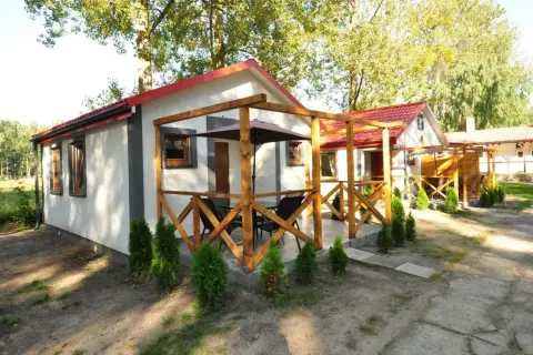 Urocze domki letniskowe "Albatros" w Łebie, z drewnianymi tarasami i zielenią wokół, zapraszają na wypoczynek.