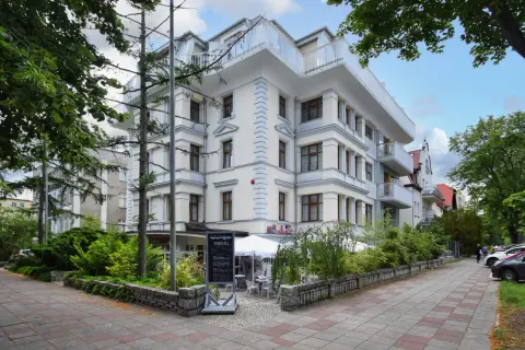 Elegancki budynek w Świnoujściu, przypominający architekturą Karkonosze, z tarasami i zielenią.