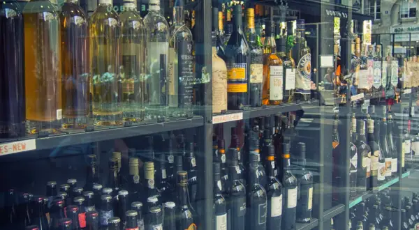 Butelki z alkoholem w witrynie sklepowej. Zastanawiasz się, ile alkoholu można przewieźć samolotem do Norwegii?