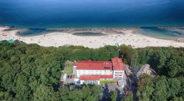 Tanie noclegi Darłówko: hotel otoczony lasem, blisko plaży pełnej turystów. Idealne miejsce na wakacje nad morzem.