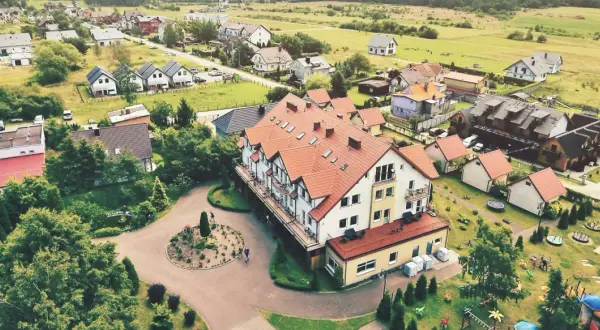 Widok z lotu ptaka na kompleks wypoczynkowy Sedna z hotelami, domkami i placem zabaw.