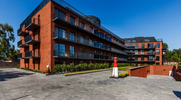 Nowoczesne apartamenty Jastrzębia Góra z balkonami i widokiem na morze. Obok latarnia morska.
