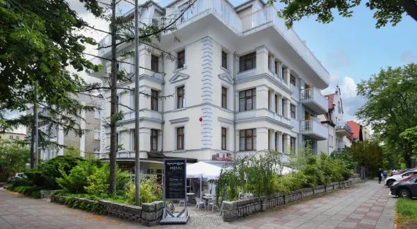 Elegancki budynek w Świnoujściu, przypominający architekturą Karkonosze, z tarasami i zielenią.