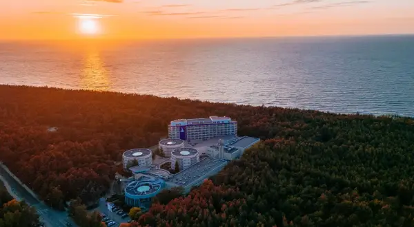 Zachód słońca nad morzem, otaczający las i kompleks hotelowy Hotel Senator Dźwirzyno.