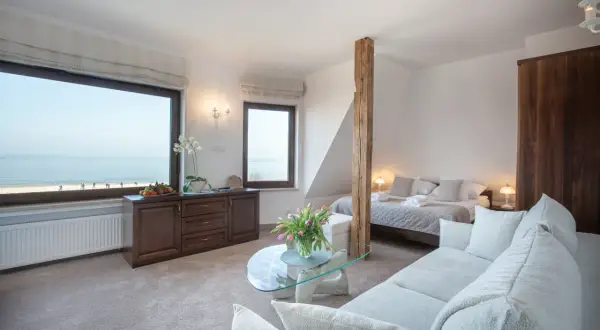 Przytulne columbus apartamenty ustka z widokiem na morze. Wygodna sofa, łóżko i stolik kawowy.