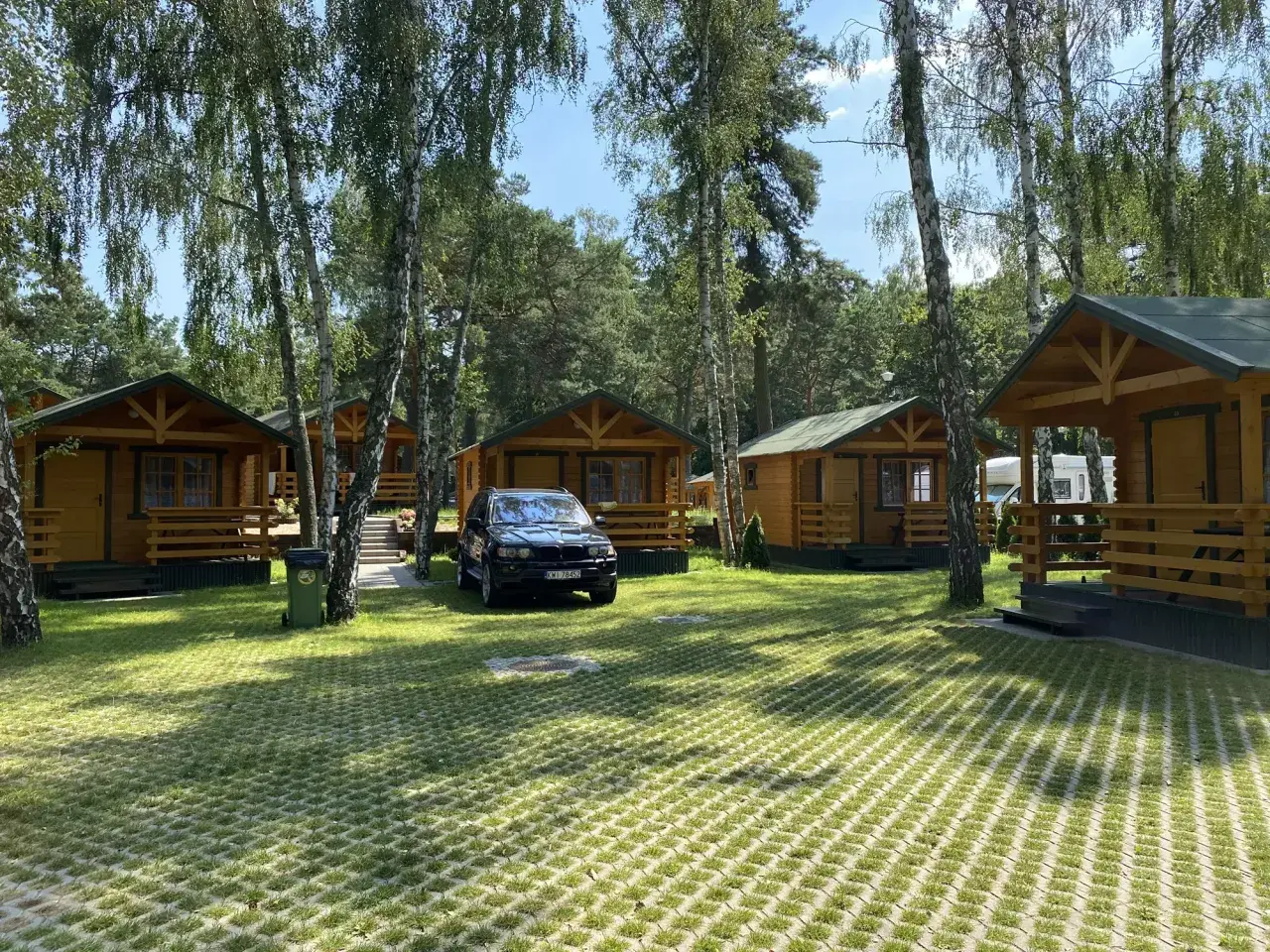 Urokliwe domki nad morzem w Gdańsku, otoczone zielenią i drzewami. Idealne miejsce na wakacyjny wypoczynek.