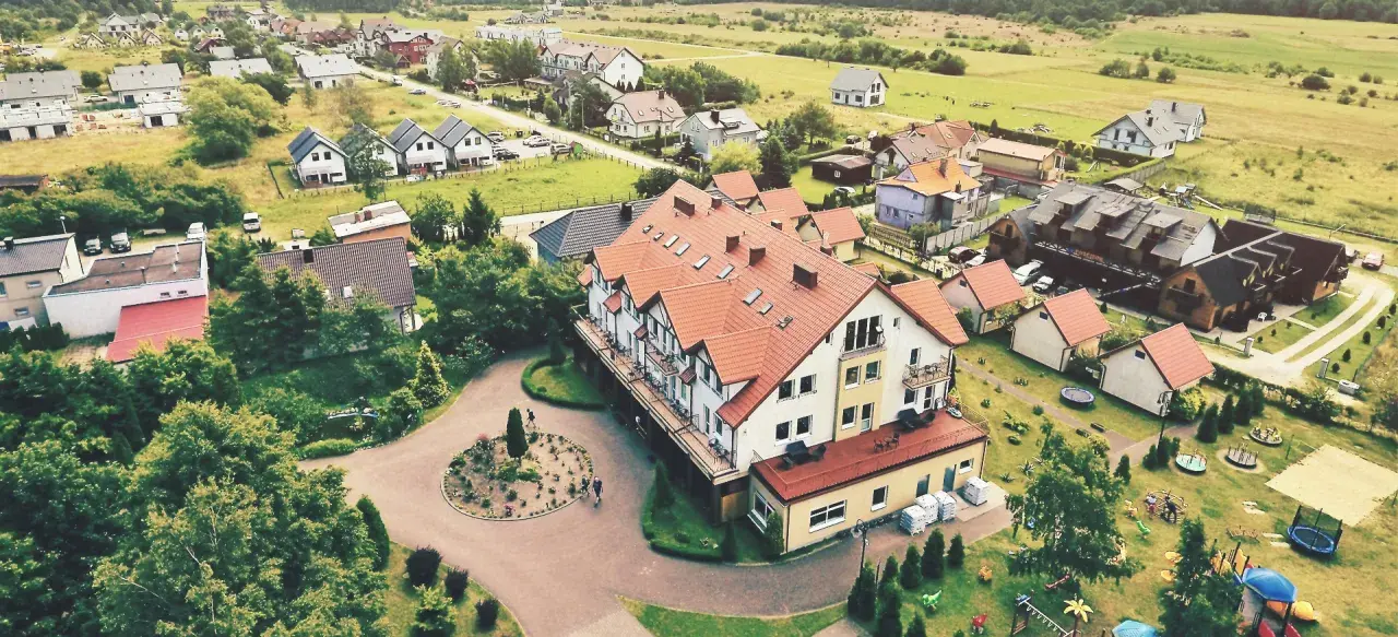 Widok z lotu ptaka na kompleks wypoczynkowy Sedna z hotelami, domkami i placem zabaw.