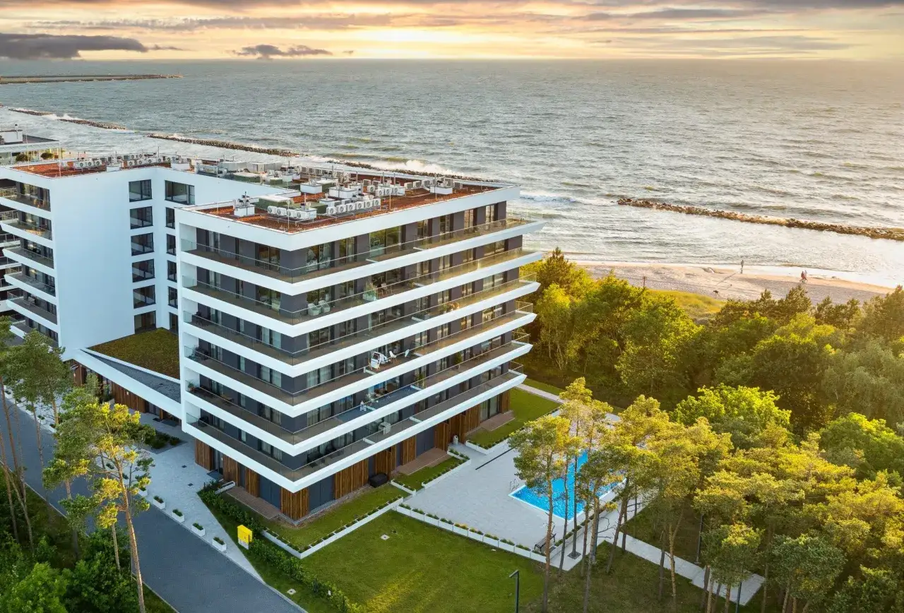 Nowoczesny apartamentowiec w Darłówku oferuje pokoje blisko morza. Basen i plaża w zasięgu ręki.
