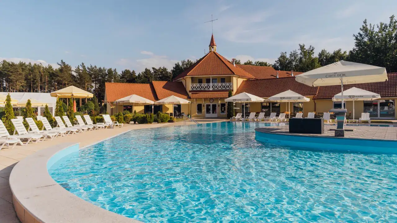 Basen z leżakami i parasolami przy hotelu w Łebie. Idealne miejsce na łeba noclegi z wyżywieniem i relaks.