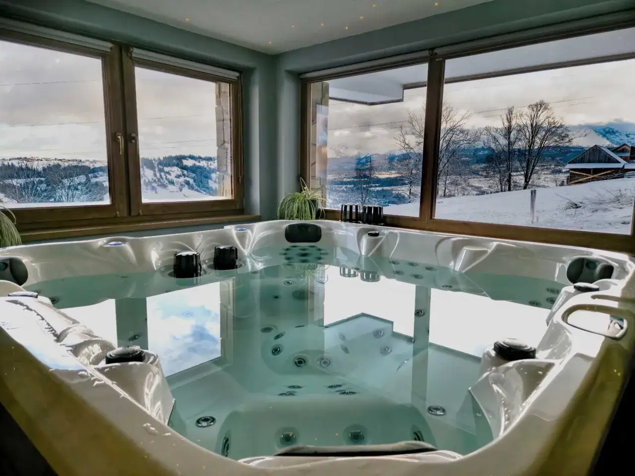 Relaks w jacuzzi z widokiem na zimowy krajobraz. Idealne miejsce na domki do wynajęcia na weekend.