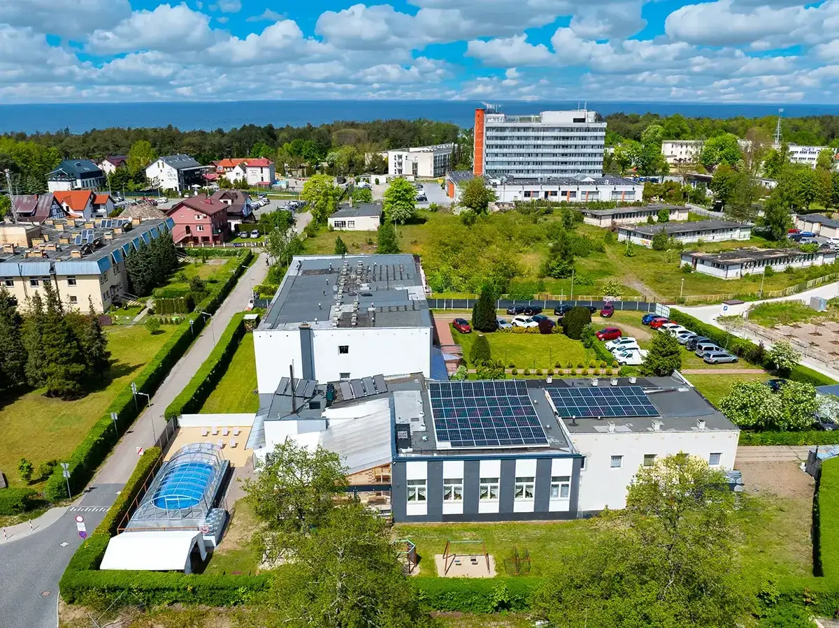 Widok z lotu ptaka na ośrodek wczasowy Maria z basenem, panelami słonecznymi i budynkami.