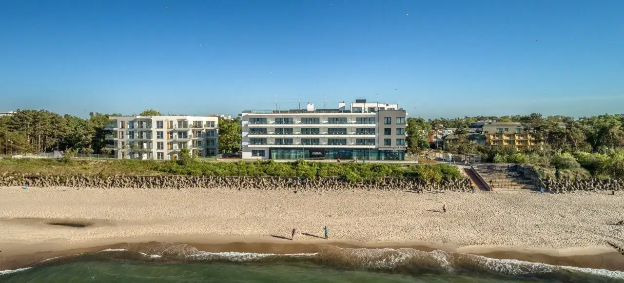 Nowoczesny hotel nad samym morzem, z widokiem na plażę i spokojne fale Bałtyku. Idealne miejsce na wypoczynek.
