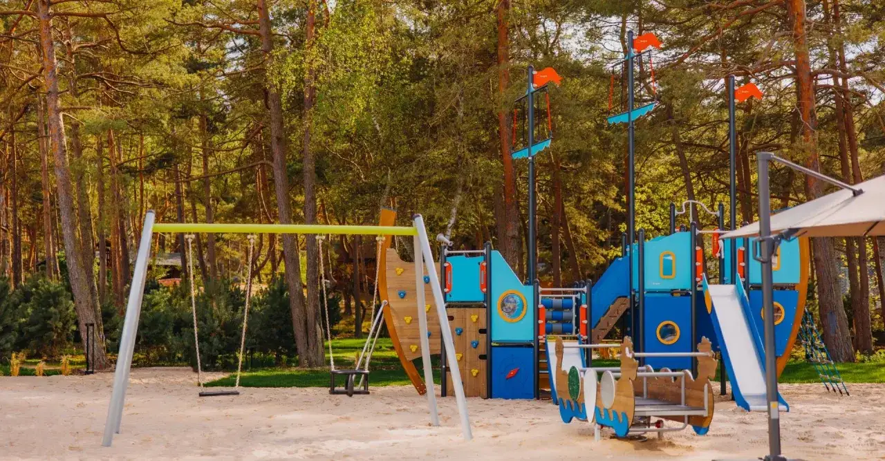 Plac zabaw w kształcie statku pirackiego, idealne miejsce, gdzie nad morze z dzieckiem. Huśtawki i zjeżdżalnie czekają na małych odkrywców.