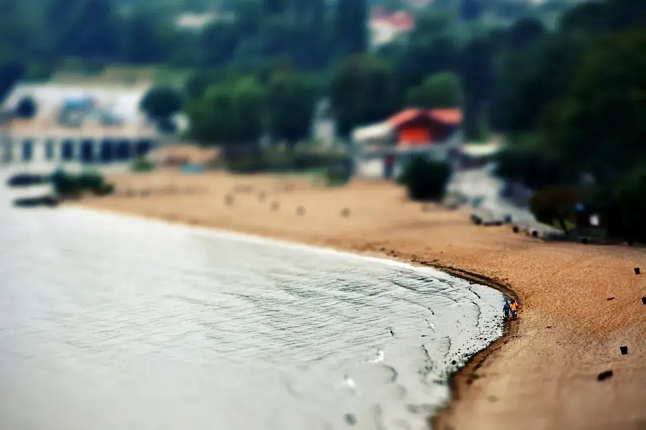 Spacerem po plaży w Dąbkach, w tle widać domki i zieleń.