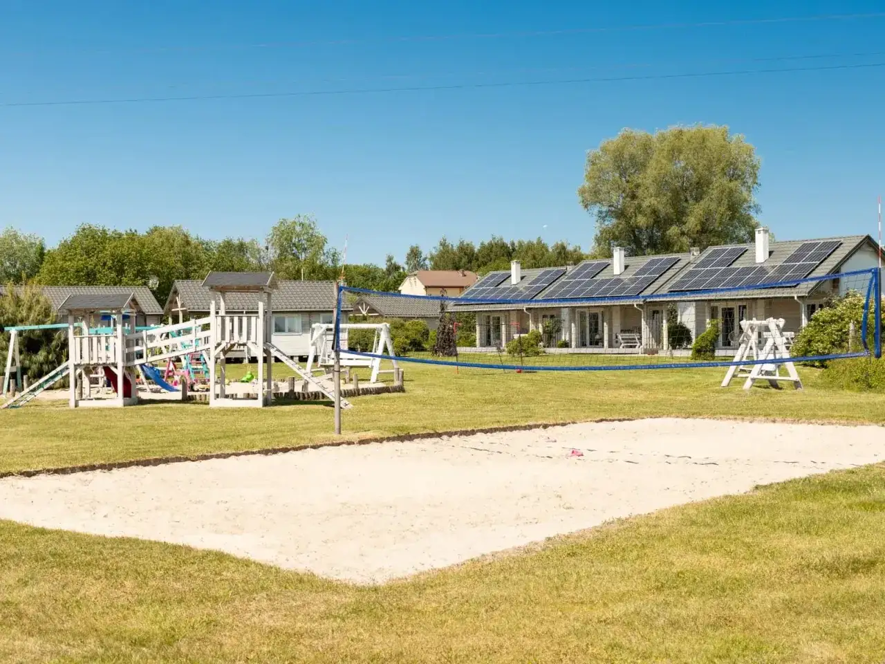 Urokliwe domki nad wodą w Mielnie, plac zabaw i boisko do siatkówki plażowej. Idealne miejsce na rodzinne wakacje.