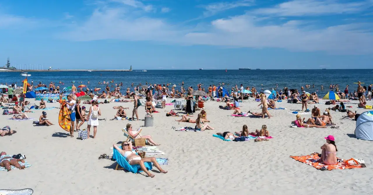 Tłumy plażowiczów w upalny dzień. Warto sprawdzić ceny noclegów nad morzem przed wyjazdem.