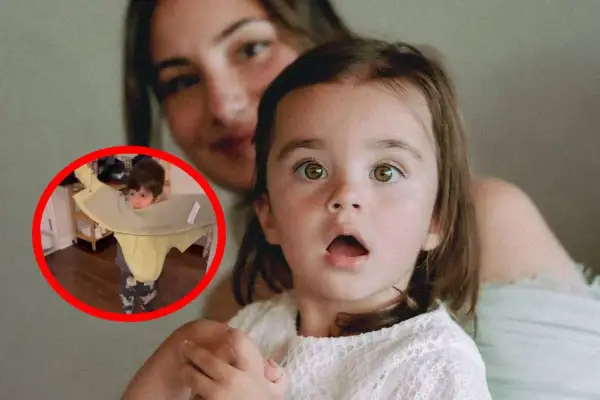 Dziecko z pomocą mamy uczy się, jak założyć kurtkę. Mama z uśmiechem obserwuje malucha.