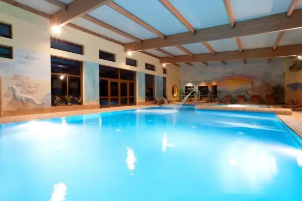Basen w Jantar Niechorze SPA z wodnym placem zabaw i malowidłami na ścianach.