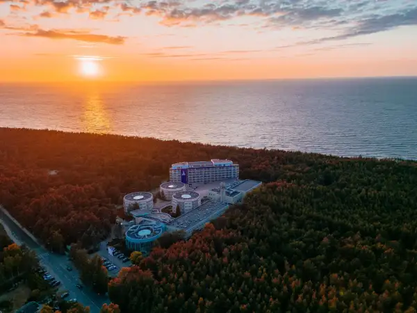 Zachód słońca nad morzem, otaczający las i kompleks hotelowy Hotel Senator Dźwirzyno.